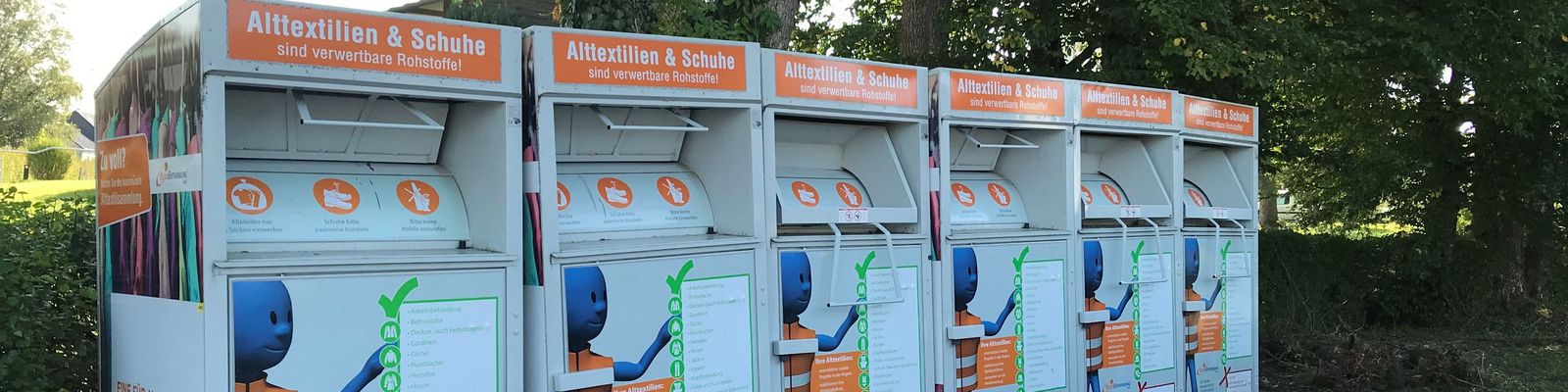 Mehrere Alttextilcontainer der RegioEntsorgung nebeneinander am Straßenrand Mehrere Alttextilcontainer der RegioEntsorgung nebeneinander am Straßenrand