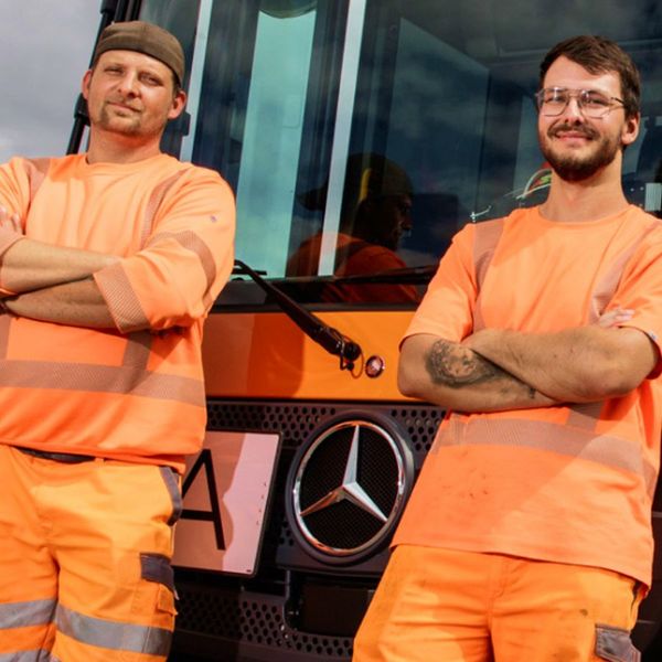 Zwei Mitarbeiter der RegioEntsorgung angelehnt am Pressmüllfahrzeug Zwei Mitarbeiter der RegioEntsorgung angelehnt am Pressmüllfahrzeug