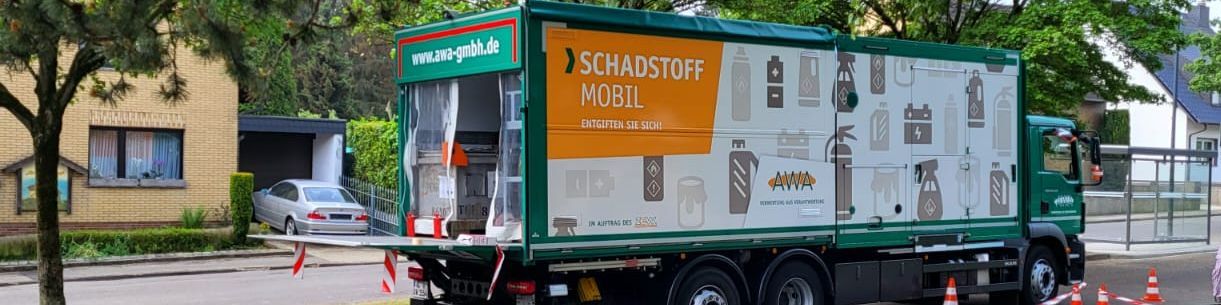 Foto von einem grünen fahrenden Schadstoffmobil der AWA auf der Straße Foto von einem grünen fahrenden Schadstoffmobil der AWA auf der Straße